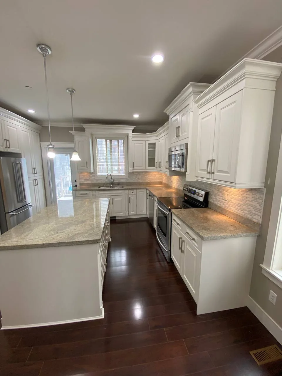 Classic white doors, detailed moulding, and a long kitchen island.